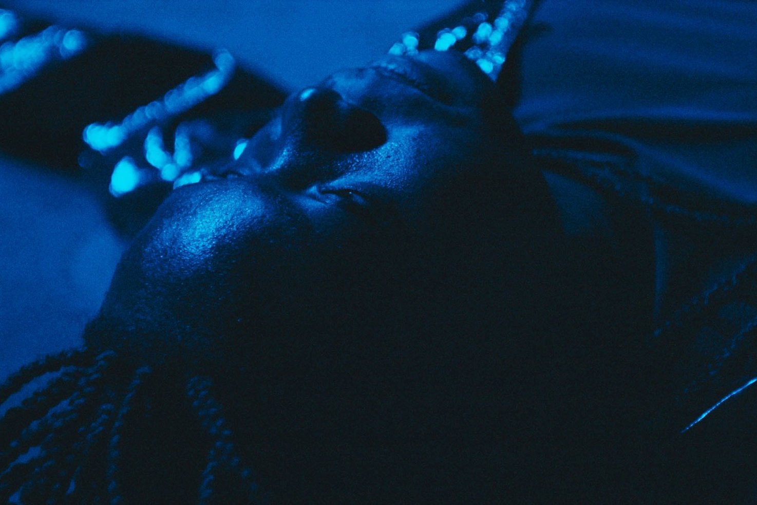Close-up of the face of a Black person in blue light